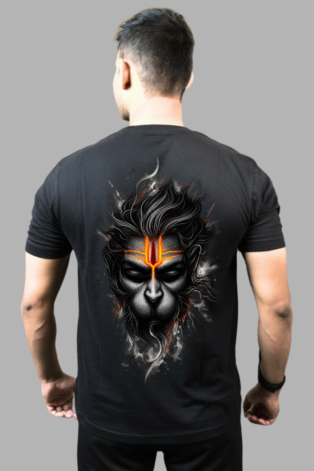 Man wearing a black regular-fit T-shirt with a monochrome Hanuman face and glowing saffron tilak printed on the back