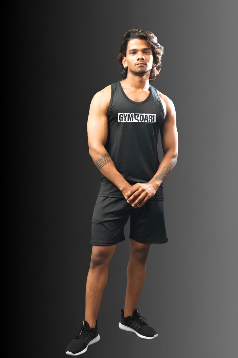 A man wearing a black athletic tank top with 'GYMCOACH' printed in white across the chest and black athletic shorts, standing against a dark gray gradient background.